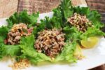 Lettuce wraps with large pieces of lettuce filled with a ground turkey mixture on top of a white platter.