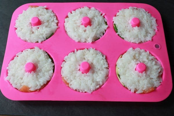 sushi donuts in a pink silicone donut mold with rice side up