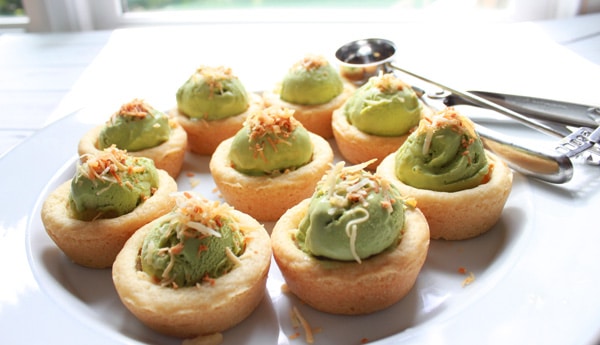 Avocado Green Tea Ice Cream Cups on a white plate with an ice cream scoop on the side.