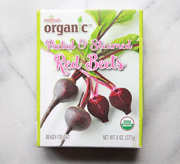 a boxed package of organic red beets  on top of a marble surface
