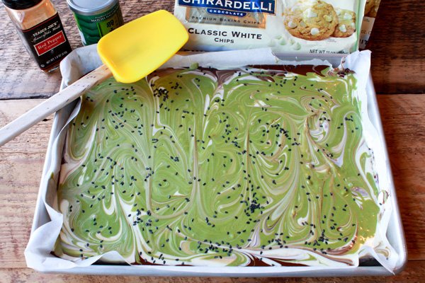 matcha holiday bark on a tray topped with sesame seeds