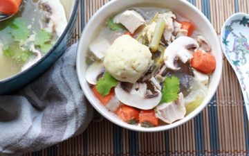 matzo ball soup in a bowl with veggies