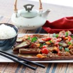 Chinese eggplant on plate topped with garlic sauce