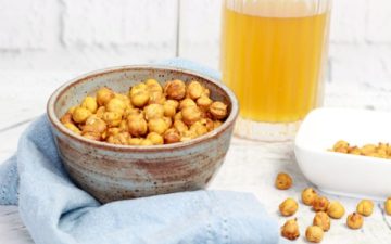 crispy spicy chickpeas in a bowl with a glass of frosty cold beer.