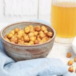 crispy spicy chickpeas in a bowl with a cold beer