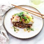 pan seared halibut on top of a bed of quinoa and topped with a spicy nuoc cham slaw