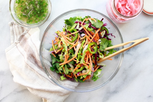 Fresh sliced veggie ingredients in a glass bowl for making Nuoc Cham Slaw