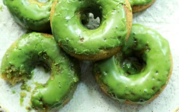 matcha donuts stacked on a white plate