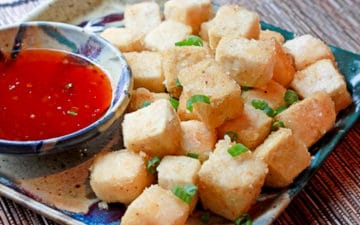 crispy tofu cubes on a plate with a side of sweet chili dipping sauce