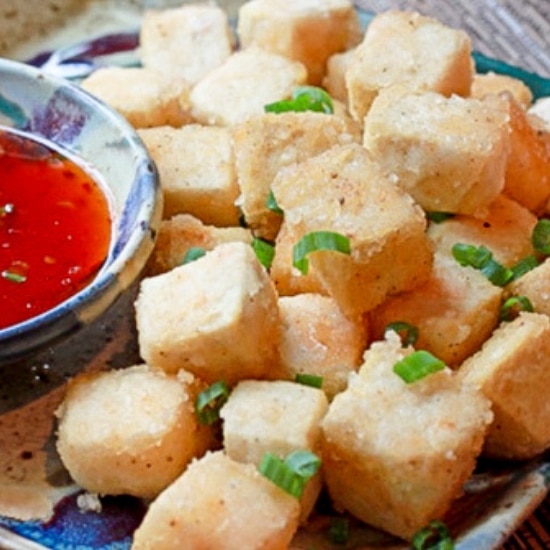 crispy tofu cubes on a plate with a side of sweet chili sauce