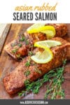 seared salmon filets on a cutting board with lemon slices
