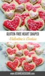 Decorated pink heart-shaped sugar cookies are stacked together.