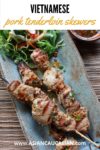 Vietnamese grilled pork tenderloin skewers on a blue dish with salad on the side
