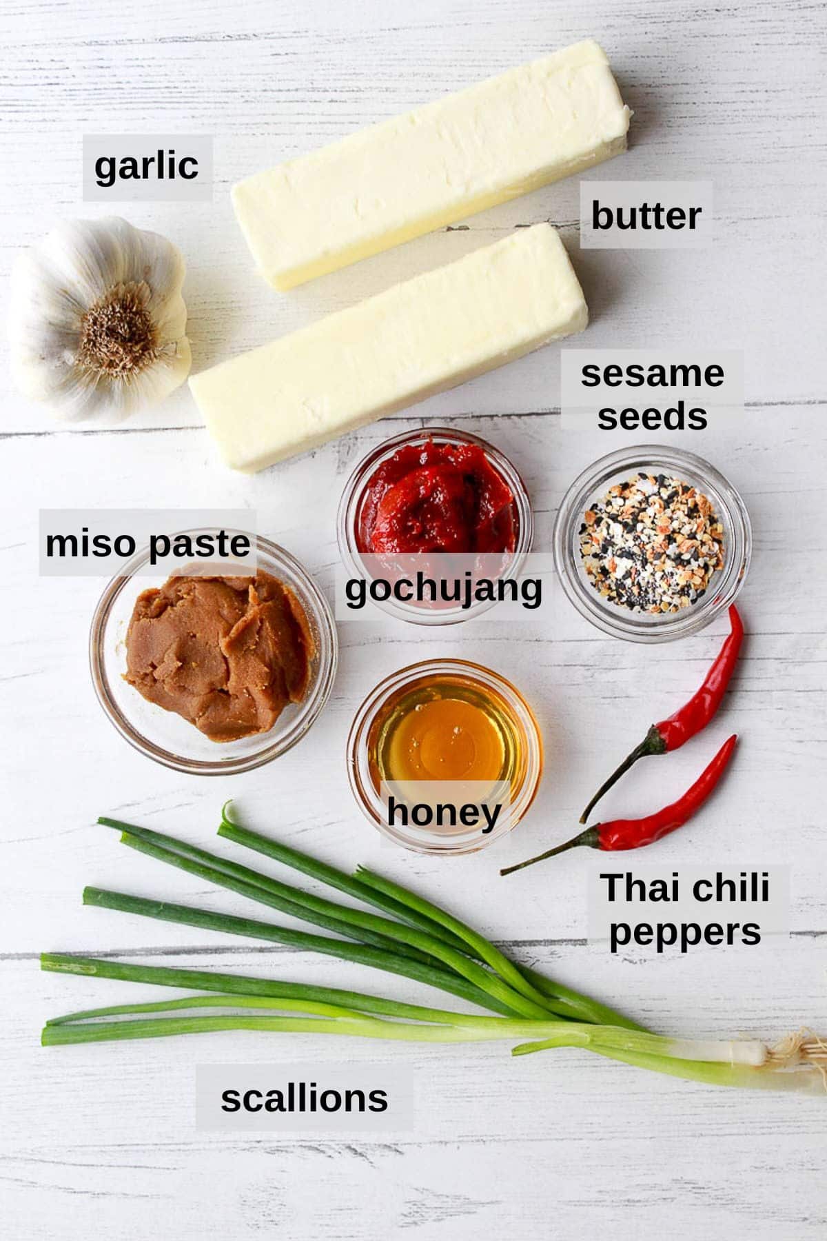 labeled ingredients in glass bowls and on top of a white board for making a miso butter board
