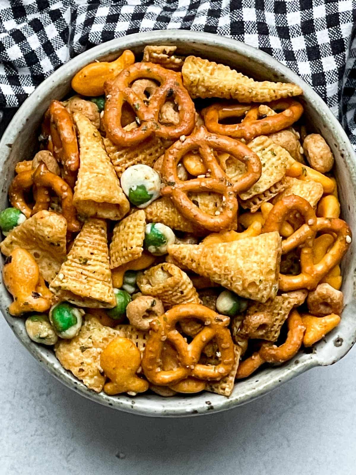 A bowl of Furikake Chex Mix on a gray surface with a black and white napkin on the side.