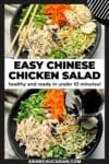A large black bowl filled with Chinese chicken salad featuring shredded chicken, shredded carrots, broccoli slaw, scallions, water chestnuts and chow mein noodles, with a pair of brown chopsticks on top and a linen napkin on the side.